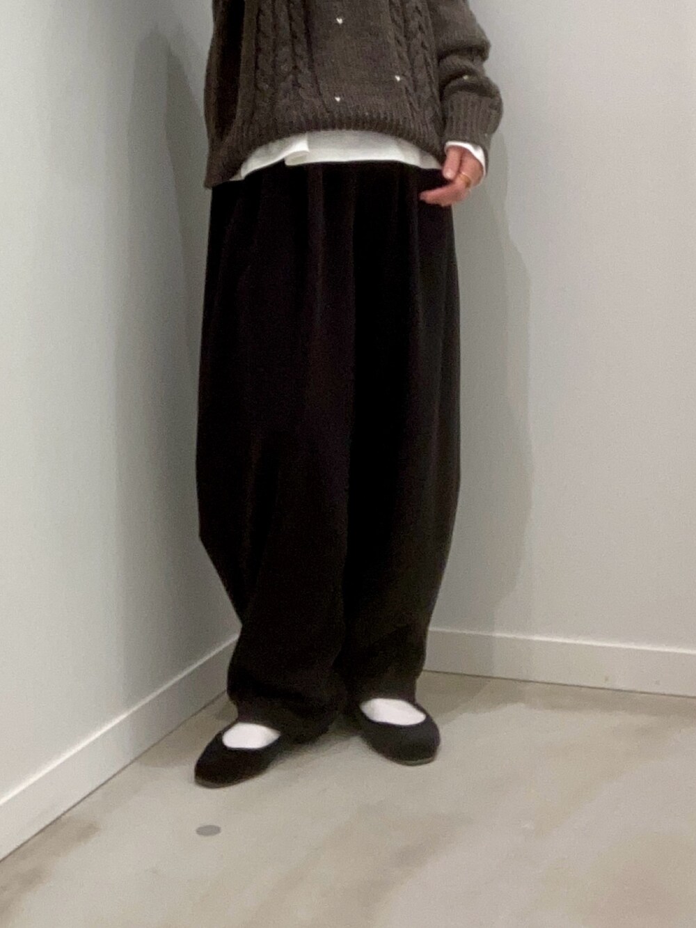 グレー系のニット/セーター、ホワイト系のTシャツ/カットソー、ブラック系のその他パンツを着用したレディースの秋コーディネートの9枚目の写真