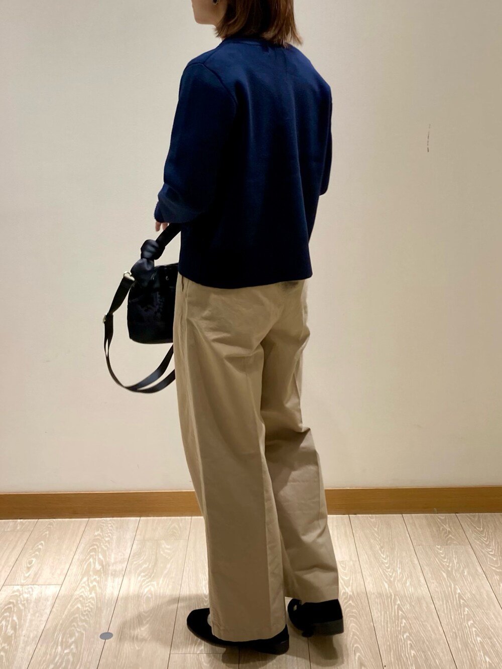 ブラック系のショルダーバッグ、ブルー系のカーディガン/ボレロ、ホワイト系のTシャツ/カットソーを着用したレディースの秋コーディネートの5枚目の写真