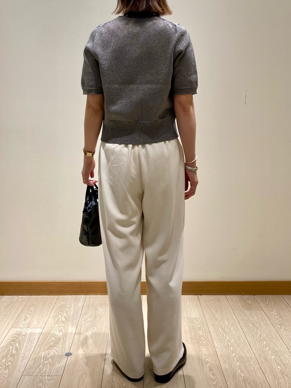 ホワイト系のその他パンツ、ブラック系のショルダーバッグ、グレー系のニット/セーターを着用したレディースの秋コーディネートの4枚目の写真