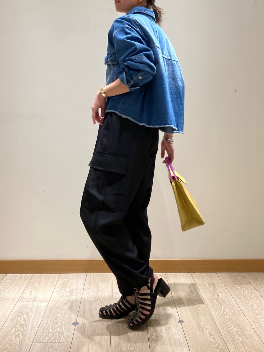 ブラック系のその他パンツ、イエロー系のかごバッグ、ブルー系のシャツ/ブラウスを着用したレディースの春コーディネートの5枚目の写真