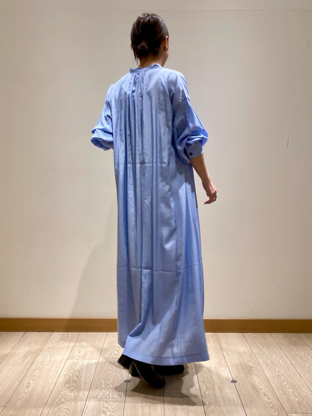 ブルー系のワンピース、ホワイト系のトートバッグ、ゴールド系のネックレスを着用したレディースの春コーディネートの4枚目の写真