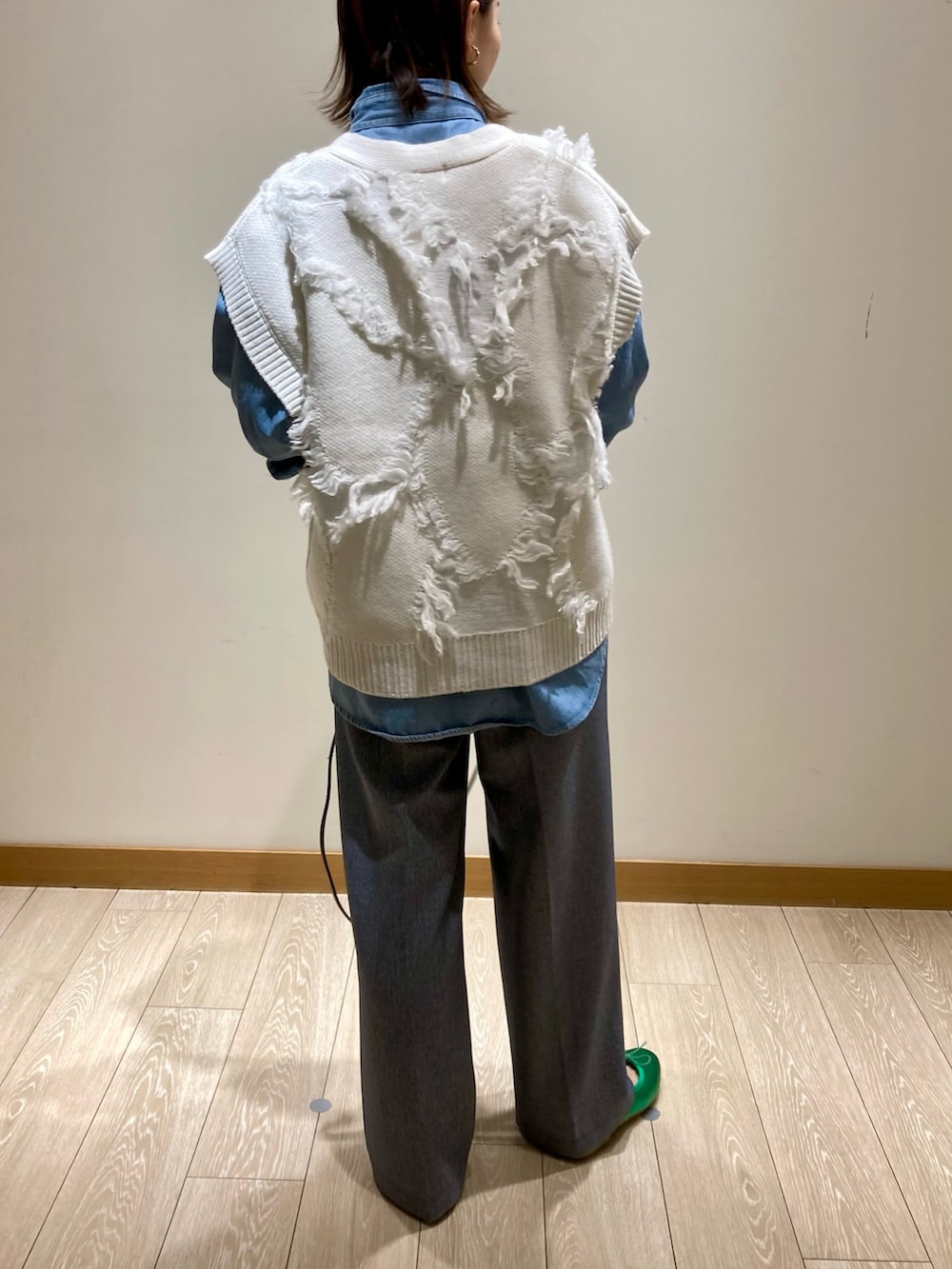 ブラック系のトートバッグ、ブルー系のスラックス、グリーン系のバレエシューズを着用したレディースの冬コーディネートの5枚目の写真