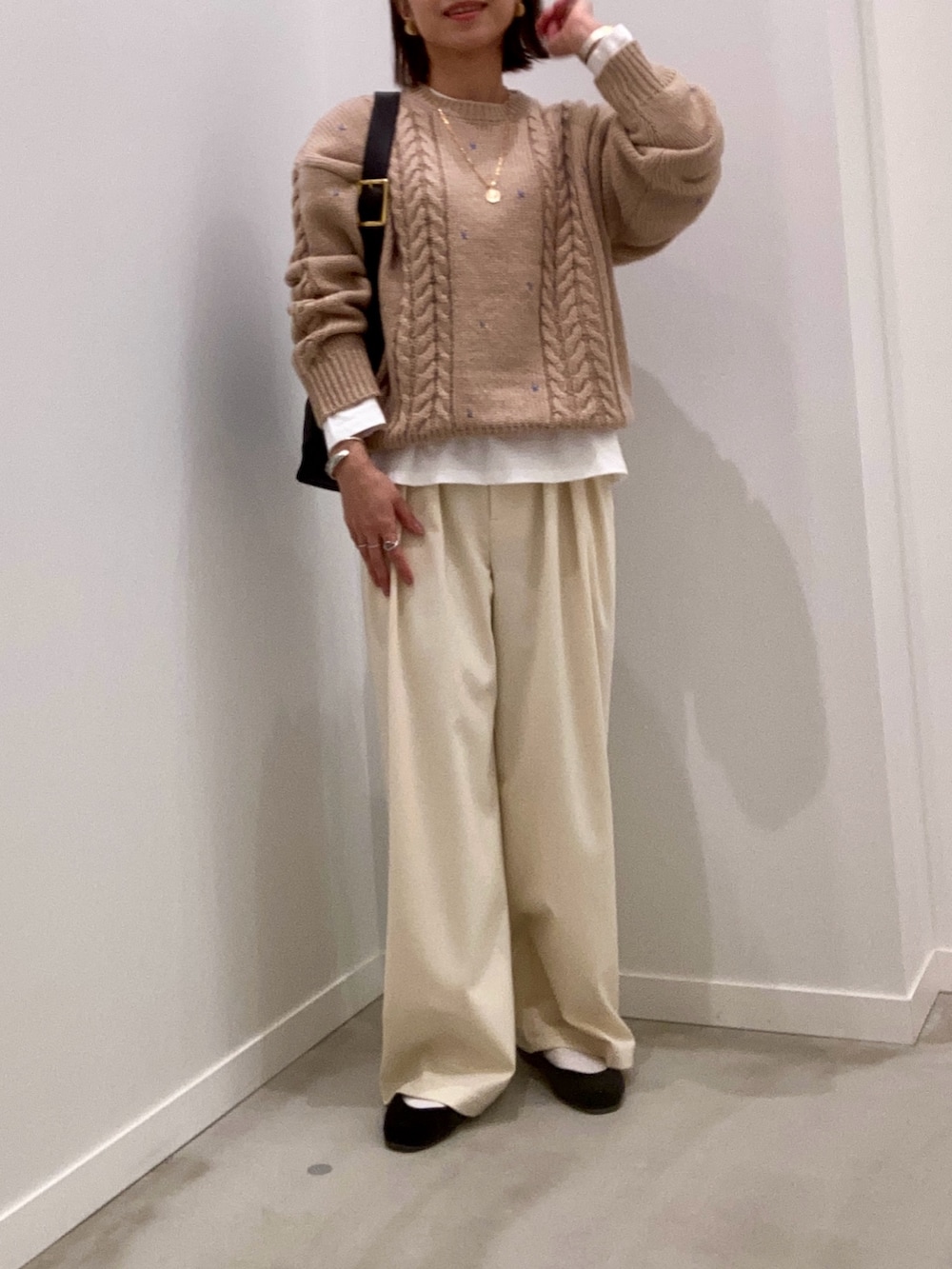 ベージュ系のニット/セーター、ホワイト系のTシャツ/カットソー、ブラック系のショルダーバッグを着用したレディースの秋コーディネートの6枚目の写真