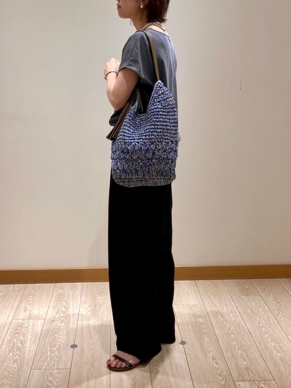 グレー系のTシャツ/カットソー、ブルー系のかごバッグ、ブラック系のその他パンツを着用したレディースの夏コーディネートの6枚目の写真