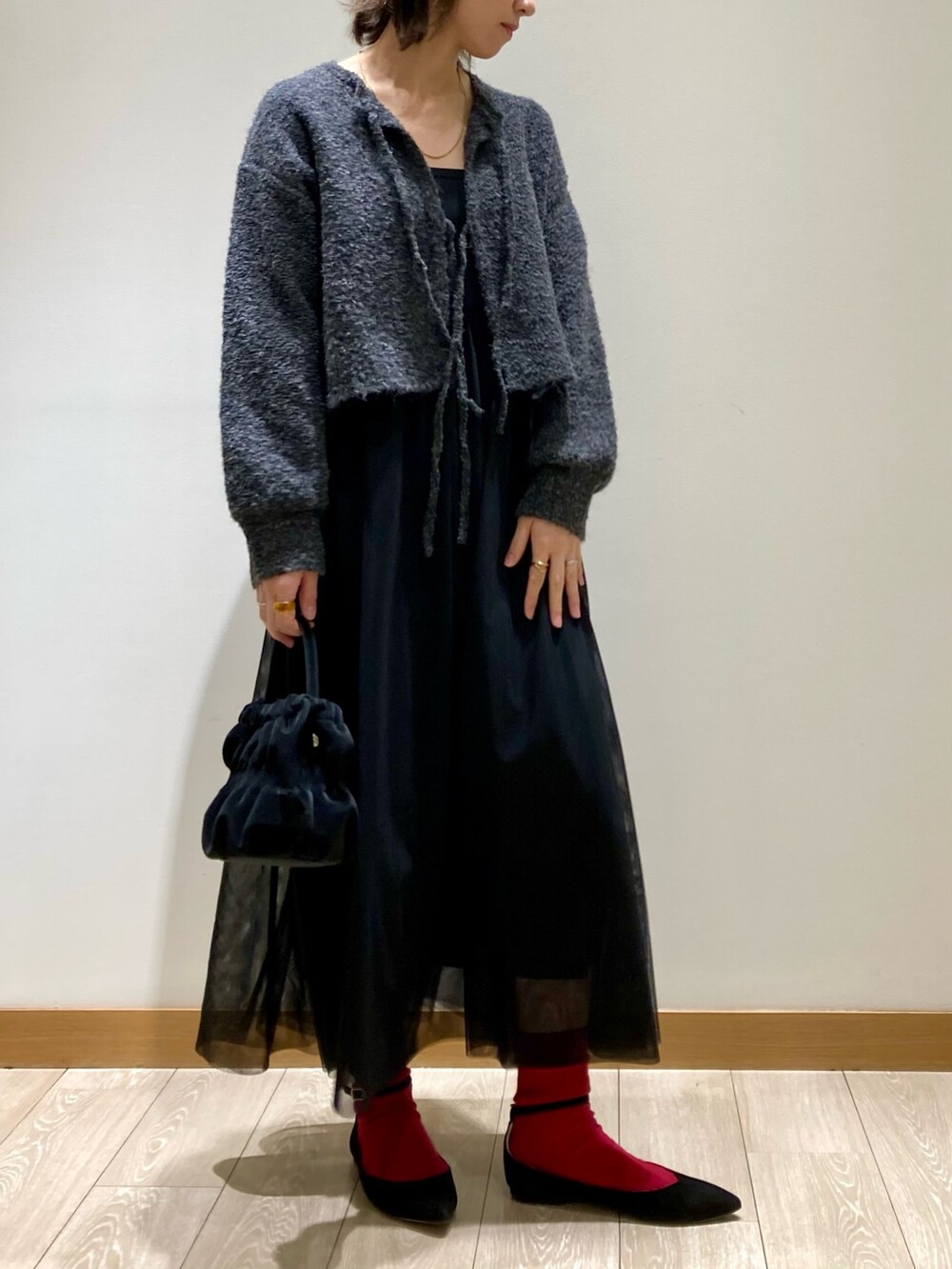 ブラック系のワンピース、ブラック系のショルダーバッグを着用したレディースの冬コーディネートの2枚目の写真