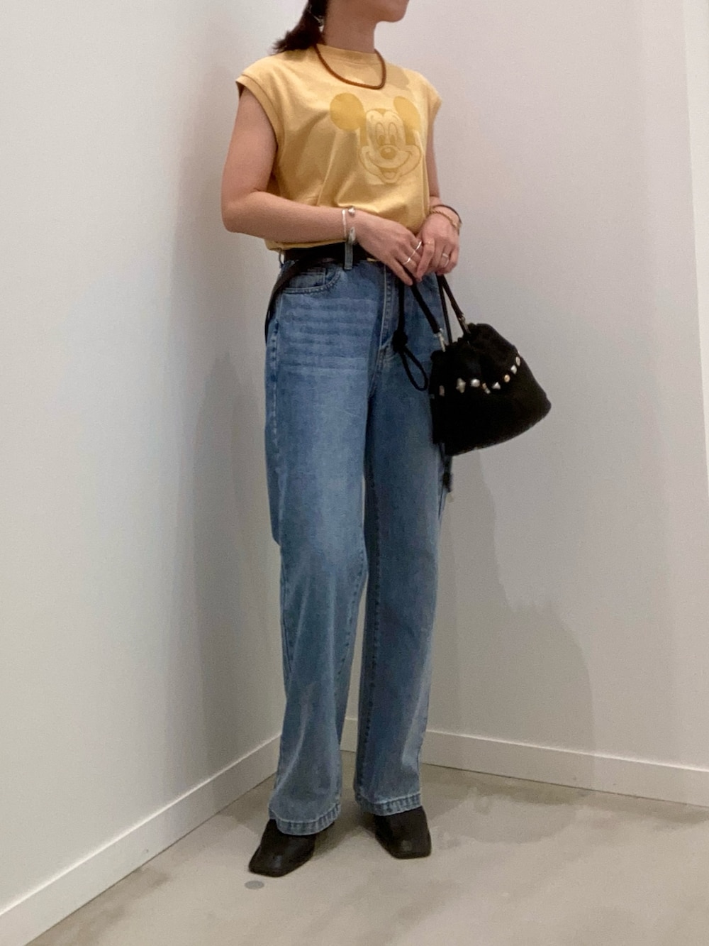 イエロー系のTシャツ/カットソー、ブルー系のデニムパンツ、ブラック系のショルダーバッグを着用したレディースの夏コーディネートの5枚目の写真