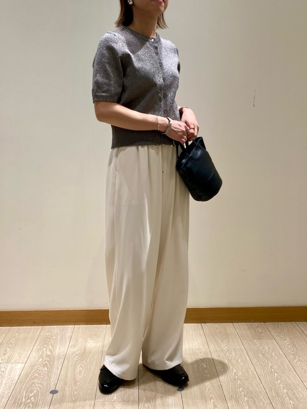 ホワイト系のその他パンツ、ブラック系のショルダーバッグ、グレー系のニット/セーターを着用したレディースの秋コーディネートの2枚目の写真
