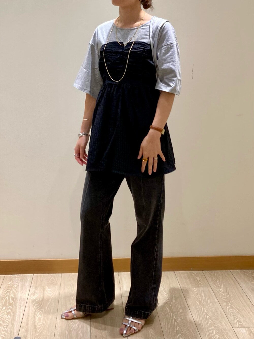 シルバー系のハンドバッグ、グレー系のTシャツ/カットソー、シルバー系のサンダルを着用したレディースの夏コーディネートの5枚目の写真