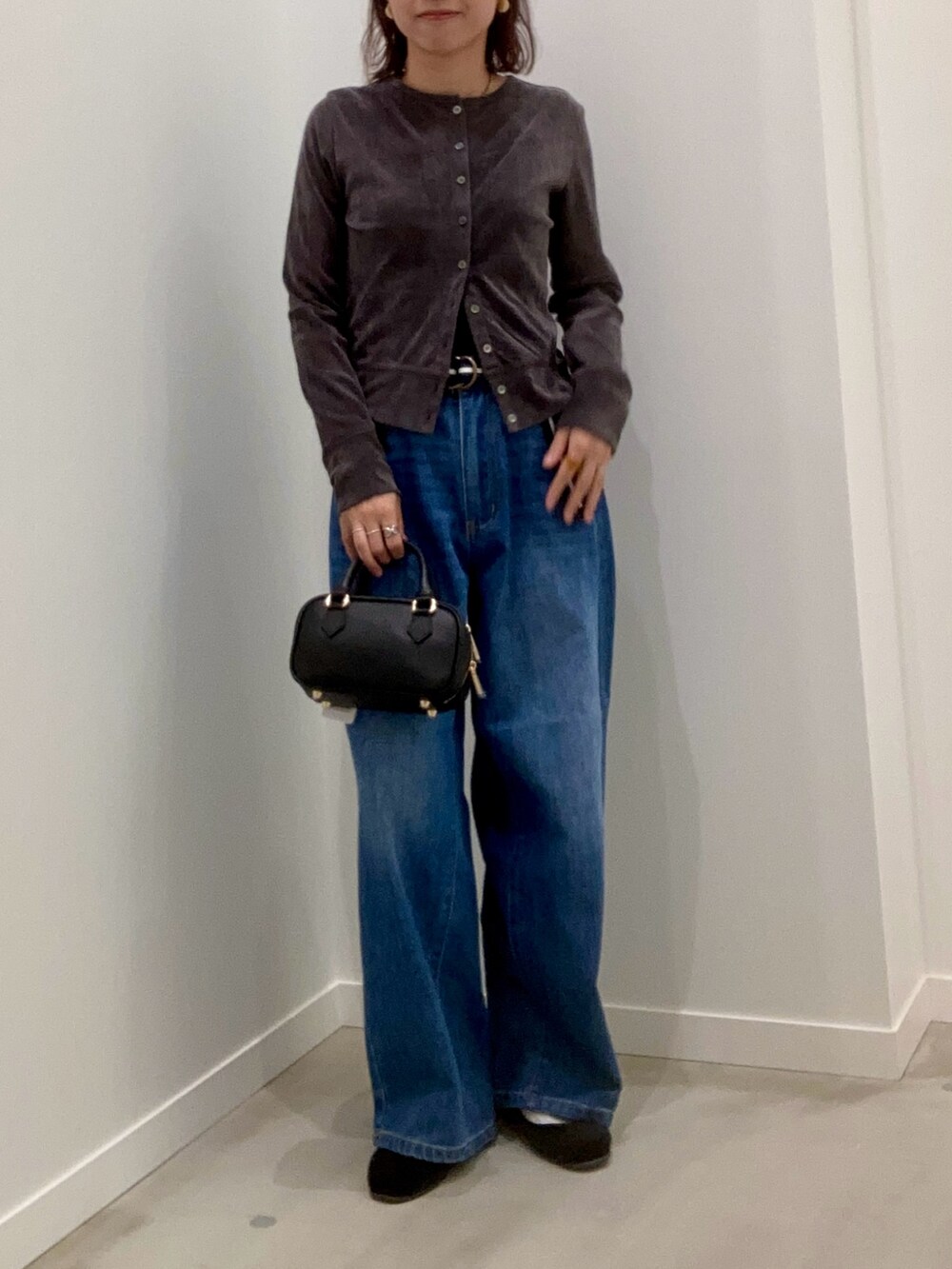 グレー系のカーディガン/ボレロ、ブルー系のデニムパンツ、ブラック系のショルダーバッグを着用したレディースの秋コーディネートの2枚目の写真