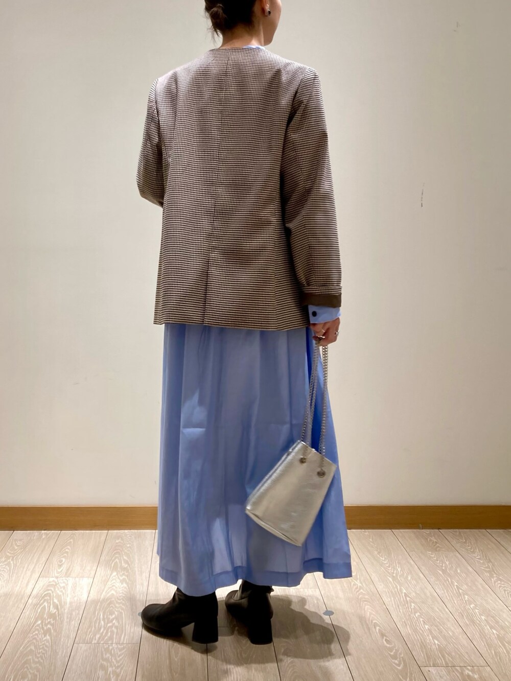 シルバー系のショルダーバッグ、ブルー系のワンピース、ベージュ系のノーカラージャケットを着用したレディースの春コーディネートの4枚目の写真