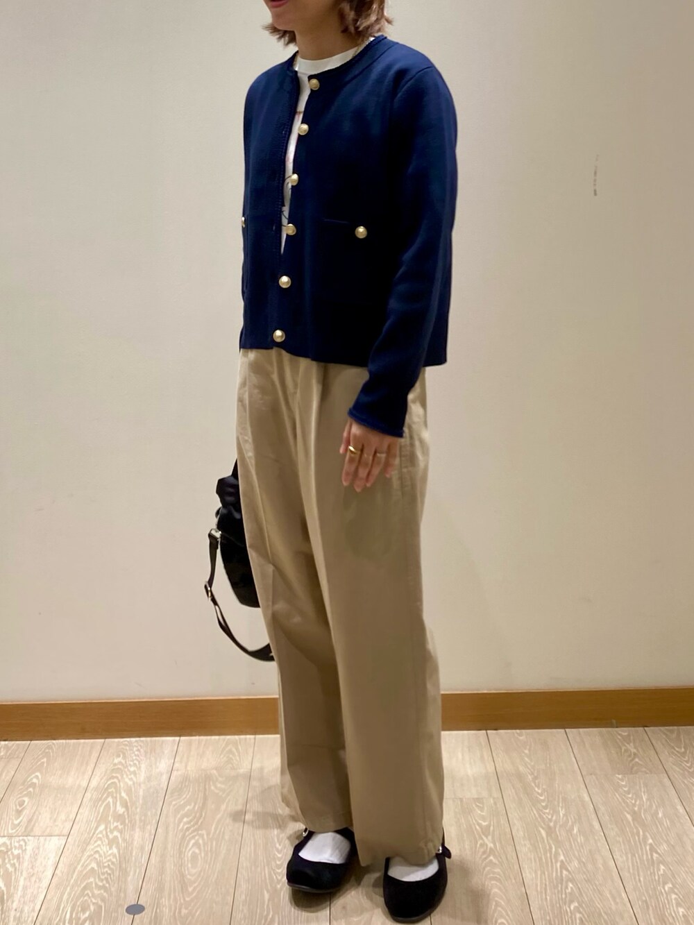 ブラック系のショルダーバッグ、ブルー系のカーディガン/ボレロ、ホワイト系のTシャツ/カットソーを着用したレディースの秋コーディネートの7枚目の写真