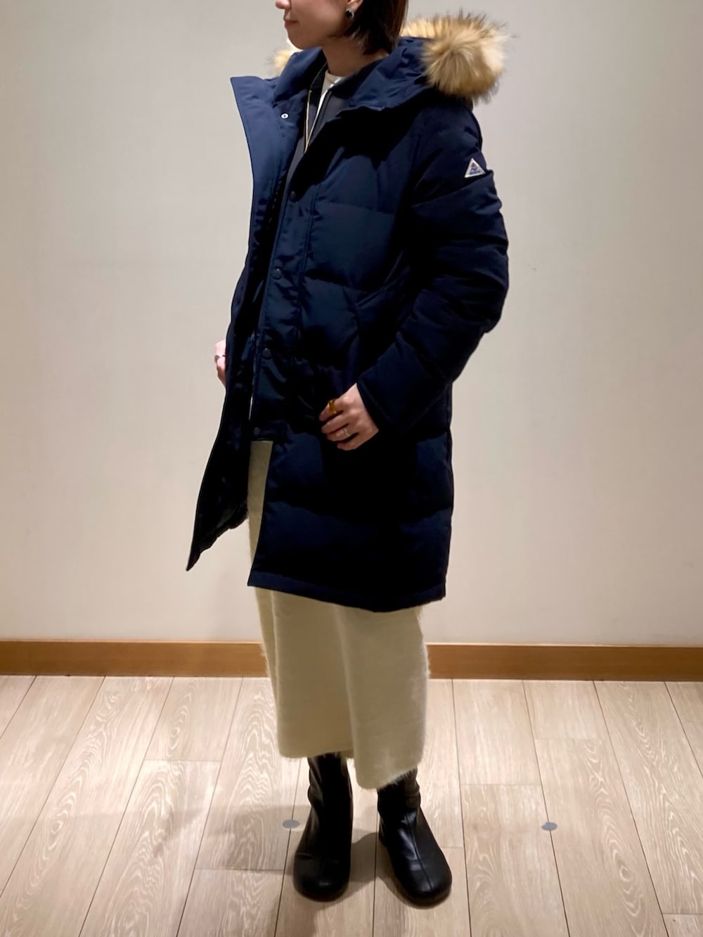 ブルー系のダウンジャケット/コート、ホワイト系のスカート、グレー系のスウェットを着用したレディースの冬コーディネートの6枚目の写真