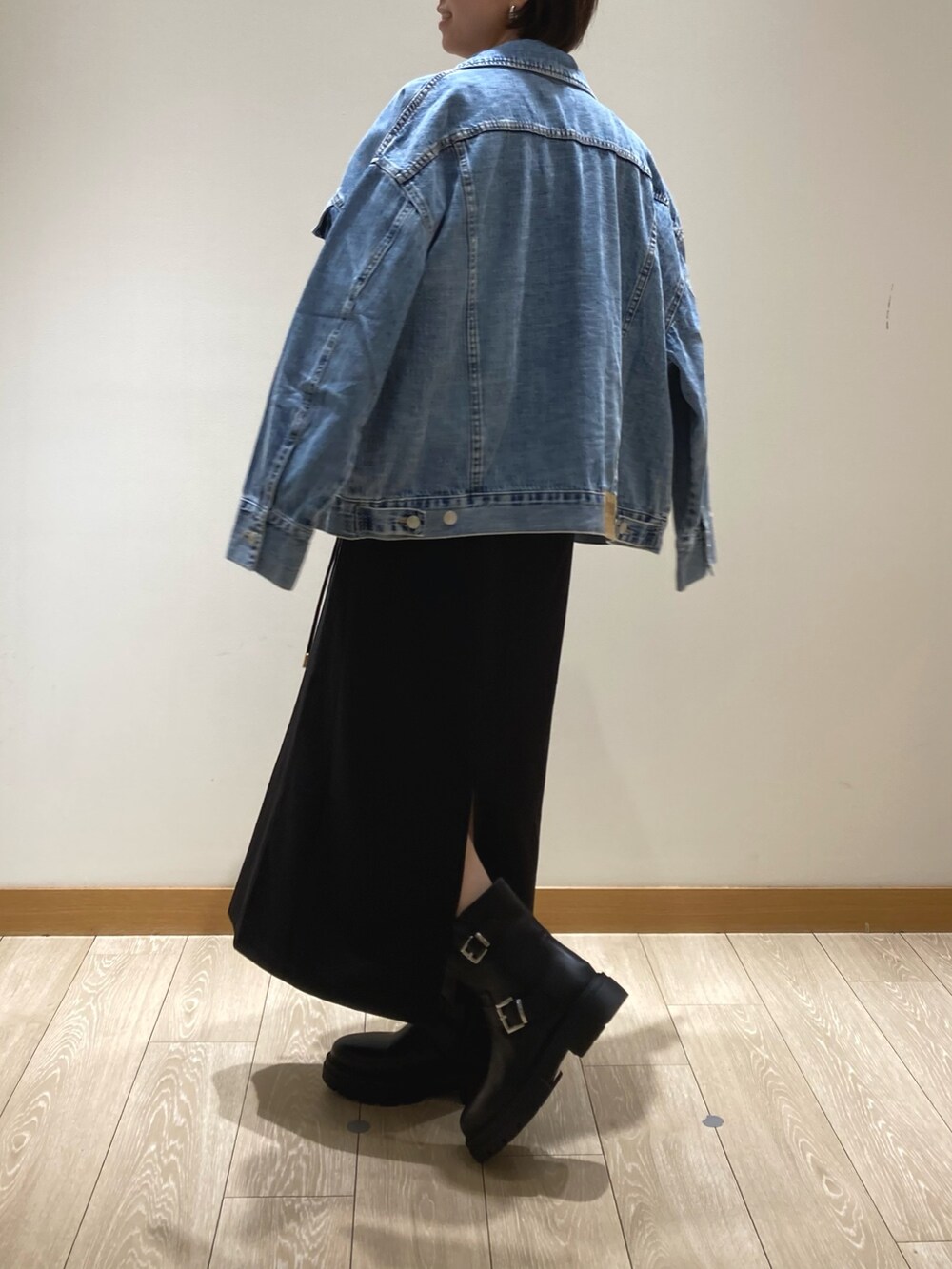 ブラック系のジャンパースカート、ブラック系のショルダーバッグ、ブラック系のブーツを着用したレディースの夏コーディネートの3枚目の写真