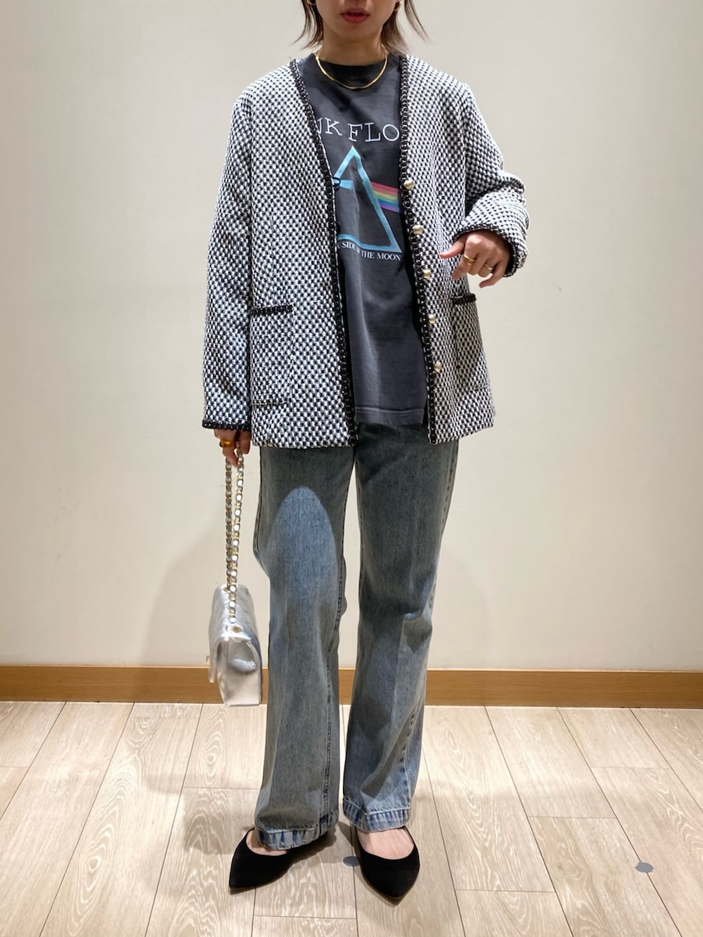 ブルー系のデニムパンツ、シルバー系のショルダーバッグ、ブラック系のノーカラージャケットを着用したレディースの冬コーディネートの2枚目の写真