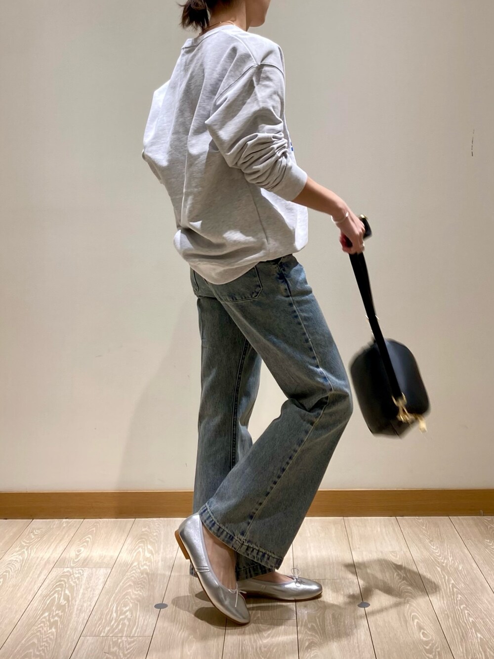 ブルー系のデニムパンツ、ブラック系のショルダーバッグ、シルバー系のバレエシューズを着用したレディースの冬コーディネートの4枚目の写真