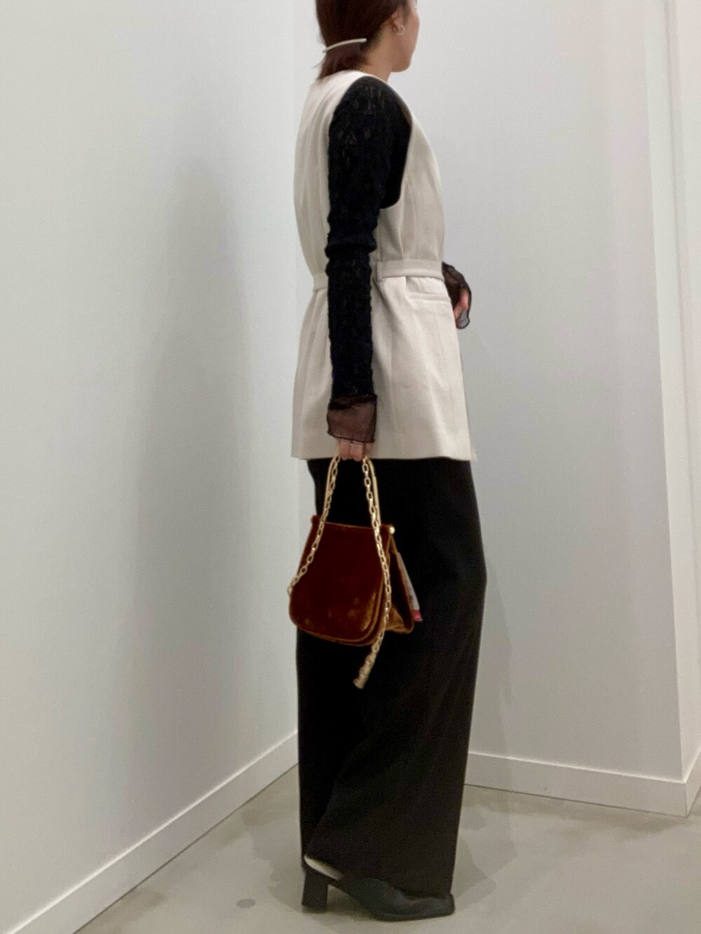 ベージュ系のベスト、ブラック系のTシャツ/カットソー、ブラウン系のショルダーバッグを着用したレディースの冬コーディネートの5枚目の写真