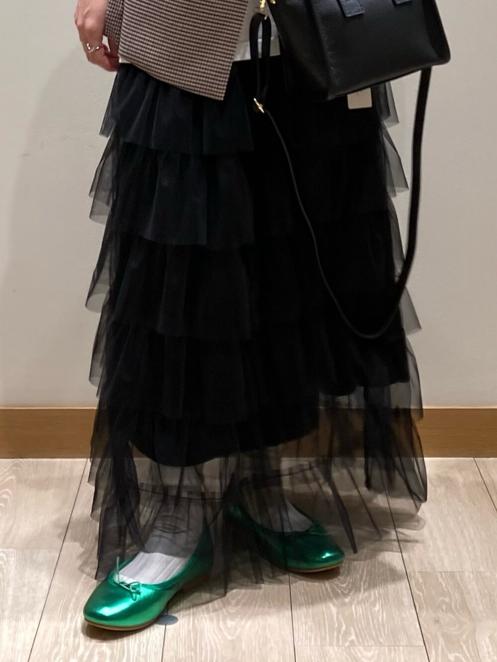 ブラック系のトートバッグ、ブラック系のスカート、グリーン系のバレエシューズを着用したレディースの春コーディネートの10枚目の写真