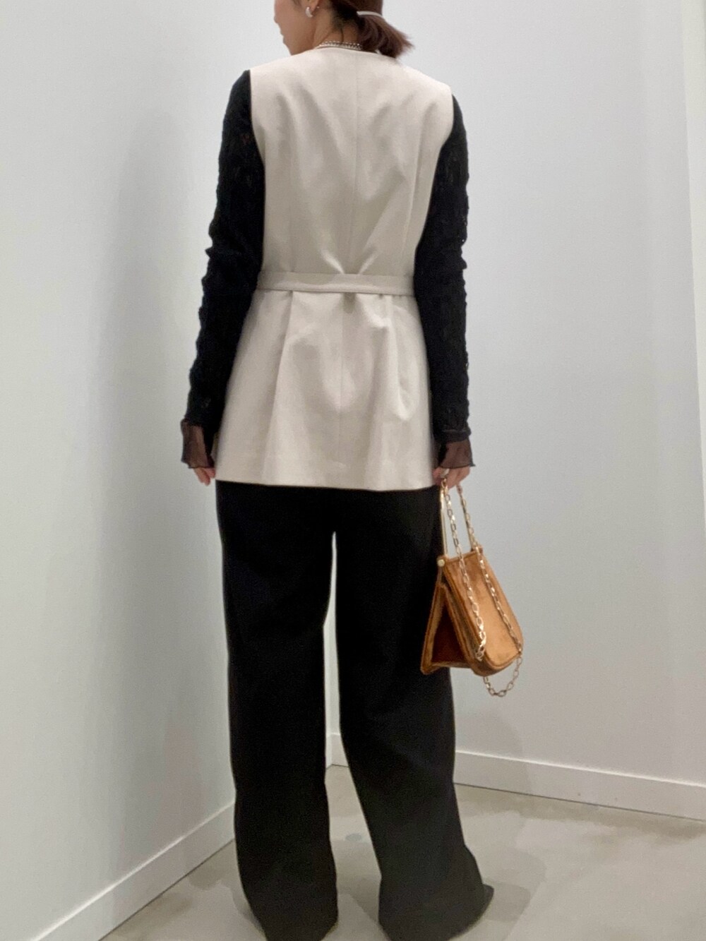 ベージュ系のベスト、ブラック系のTシャツ/カットソー、ブラウン系のショルダーバッグを着用したレディースの冬コーディネートの6枚目の写真