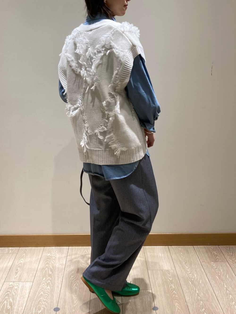 ブラック系のトートバッグ、ブルー系のスラックス、グリーン系のバレエシューズを着用したレディースの冬コーディネートの4枚目の写真