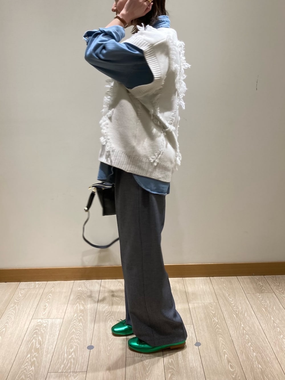 ブラック系のトートバッグ、ブルー系のスラックス、グリーン系のバレエシューズを着用したレディースの冬コーディネートの7枚目の写真