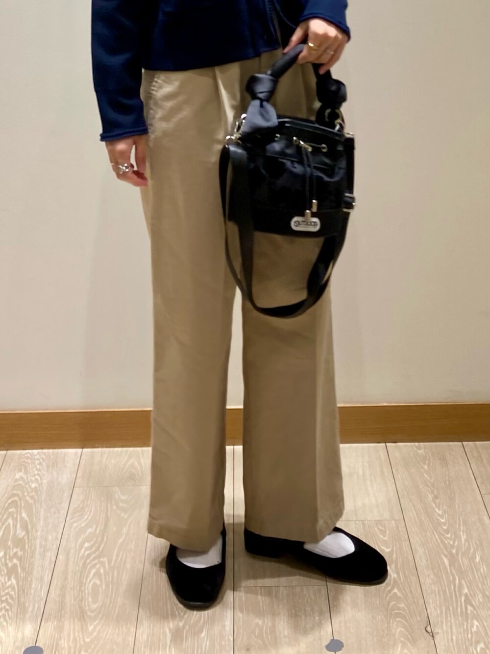 ブラック系のショルダーバッグ、ブルー系のカーディガン/ボレロ、ホワイト系のTシャツ/カットソーを着用したレディースの秋コーディネートの9枚目の写真