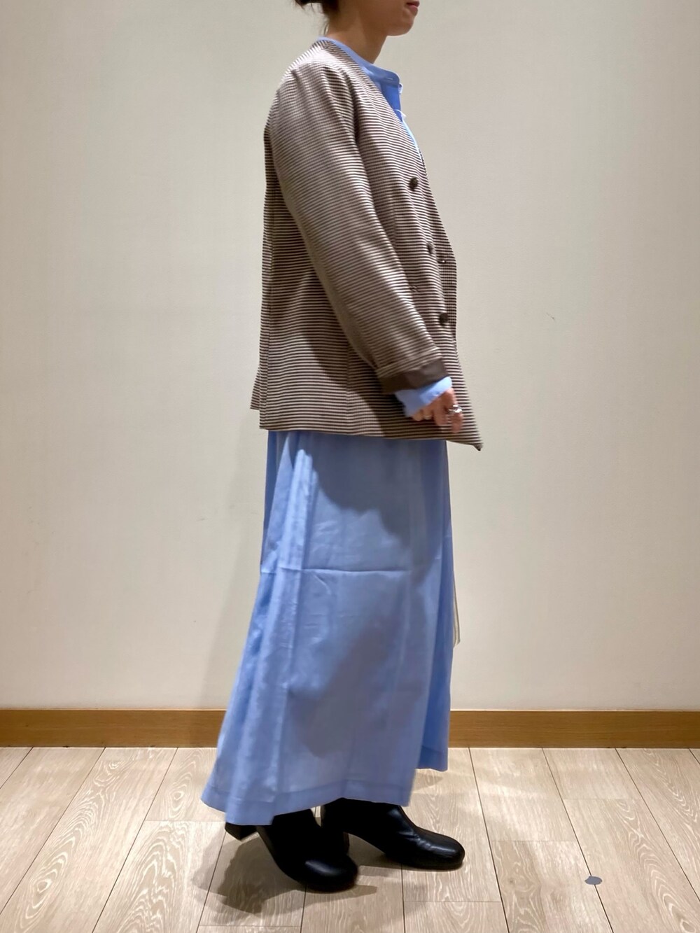 シルバー系のショルダーバッグ、ブルー系のワンピース、ベージュ系のノーカラージャケットを着用したレディースの春コーディネートの3枚目の写真