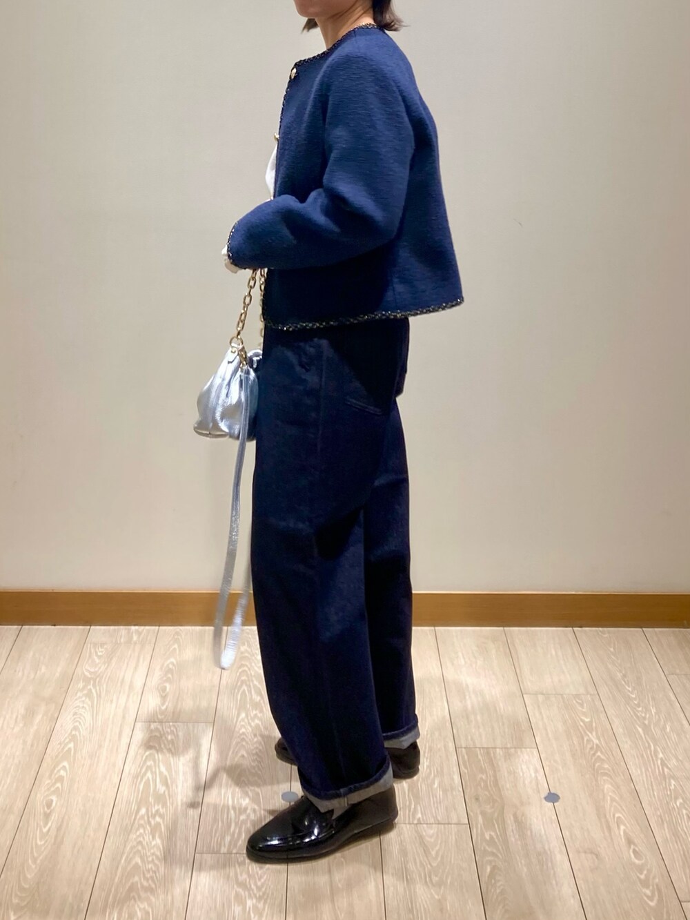 シルバー系のショルダーバッグ、ブルー系のノーカラージャケット、ホワイト系のシャツ/ブラウスを着用したレディースの春コーディネートの7枚目の写真