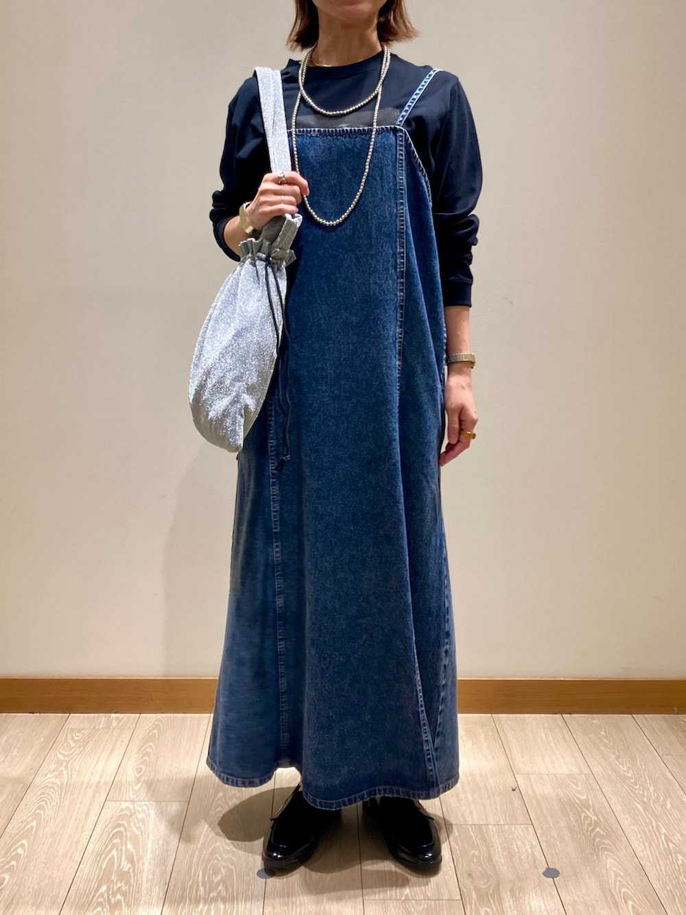 ブラック系のTシャツ/カットソー、ブルー系のワンピース、シルバー系のトートバッグを着用したレディースの秋コーディネートの8枚目の写真