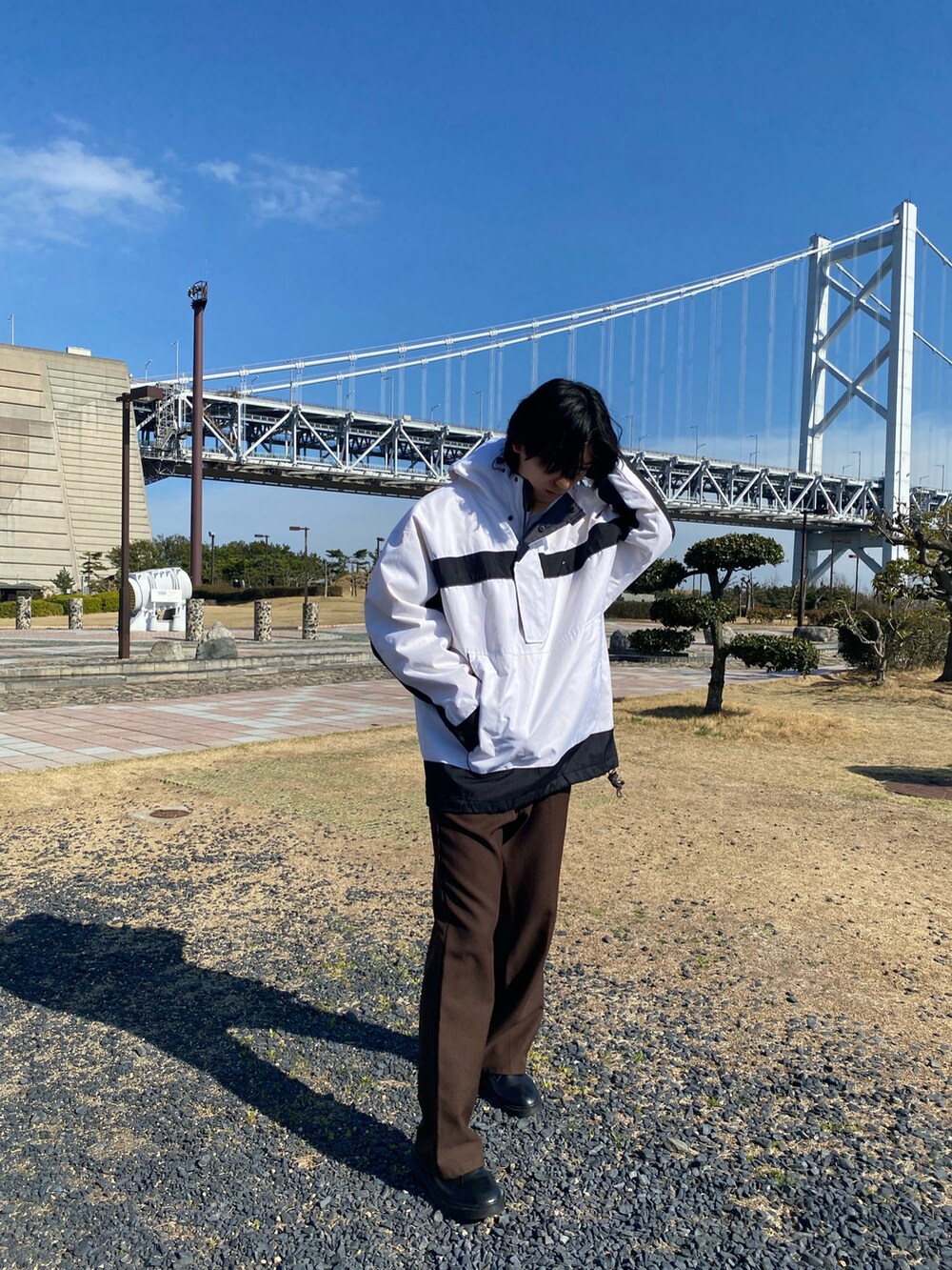 ブラウン系のスラックスを着用したメンズの春コーディネートの3枚目の写真