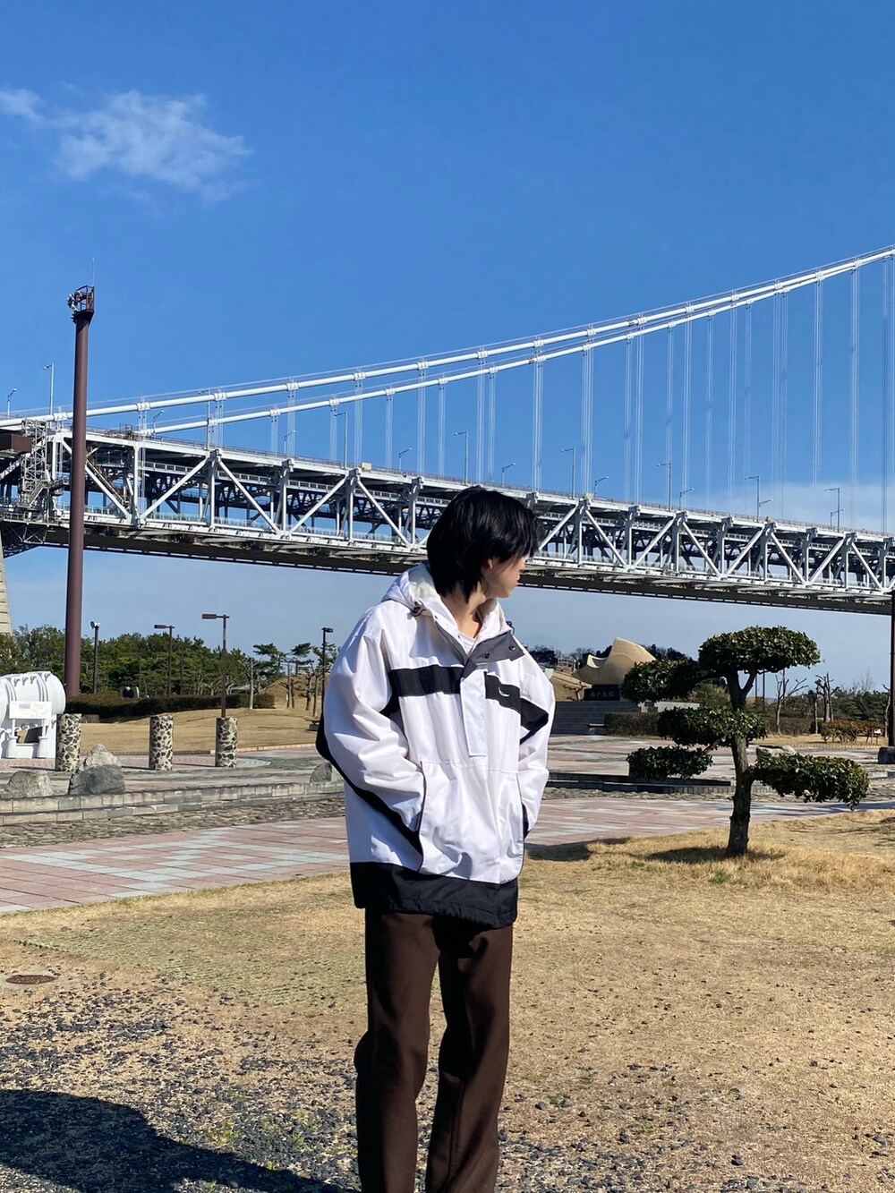 ブラウン系のスラックスを着用したメンズの春コーディネートの2枚目の写真