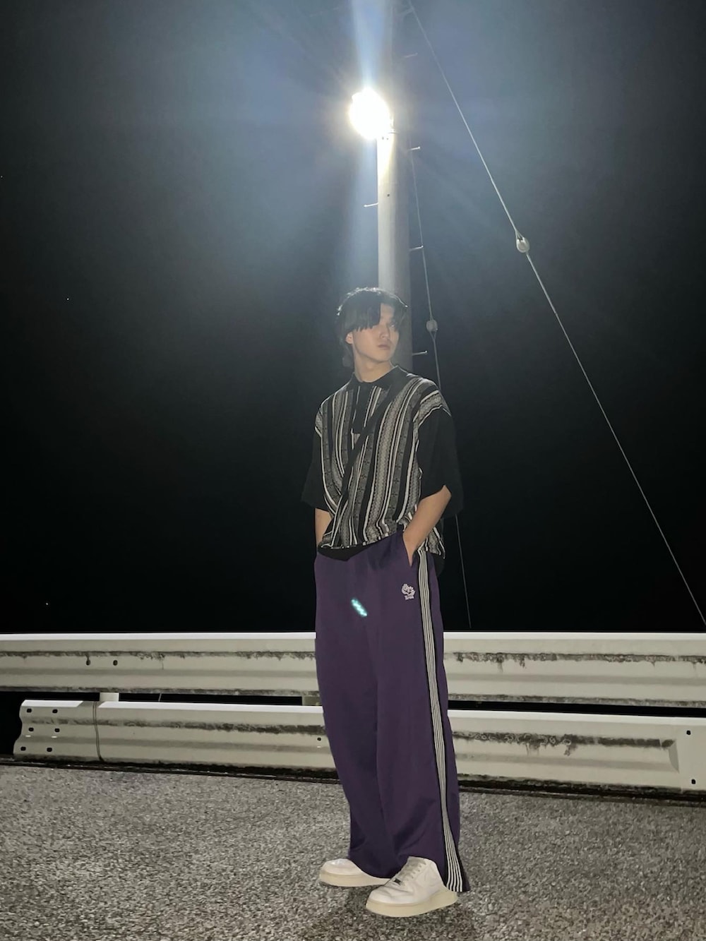 ブラック系のポロシャツ、パープル系のその他パンツ、ホワイト系のスニーカーを着用したメンズの春コーディネートの2枚目の写真