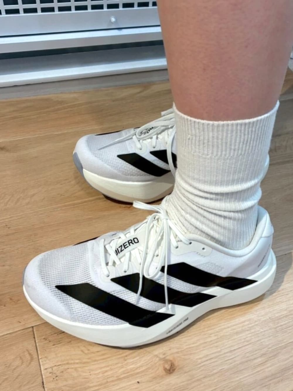 ホワイト系のスニーカー、ブラック系のその他パンツ、ブルー系のTシャツ/カットソーを着用したレディースの秋コーディネートの4枚目の写真