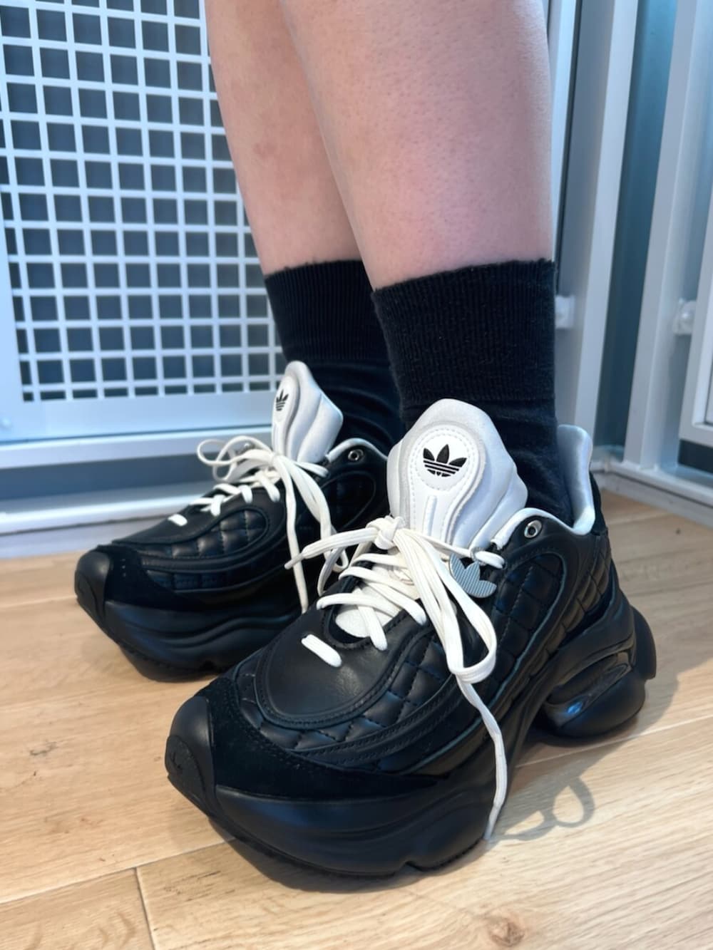 ブラック系のパーカー、ブラック系のスニーカーを着用したレディースの冬コーディネートの2枚目の写真