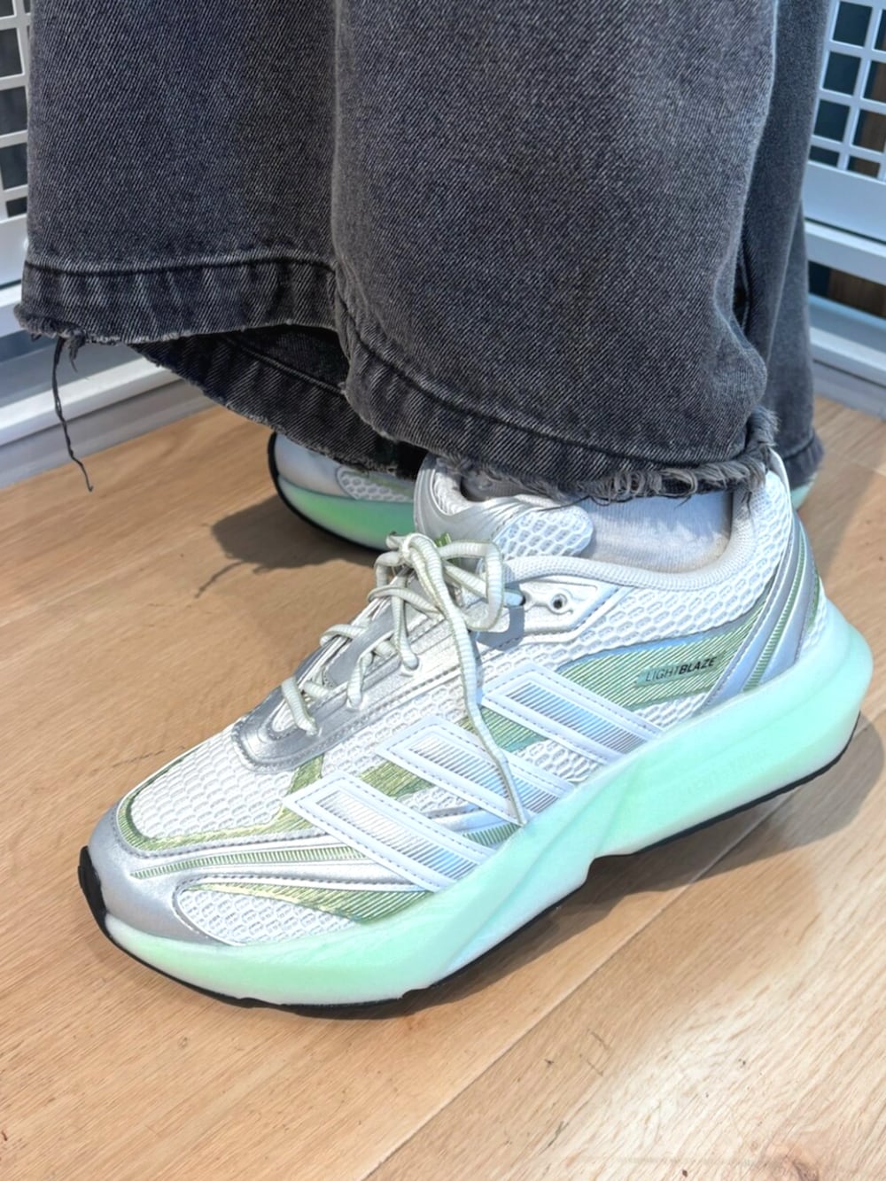 グリーン系のTシャツ/カットソー、ホワイト系のスニーカーを着用したレディースの秋コーディネートの4枚目の写真