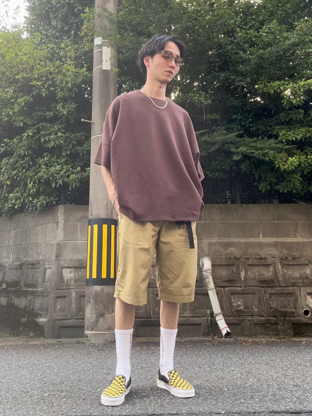 イエロー系のスニーカー、ブラウン系のTシャツ/カットソー、ベージュ系のチノパンツを着用したメンズの夏コーディネートの2枚目の写真