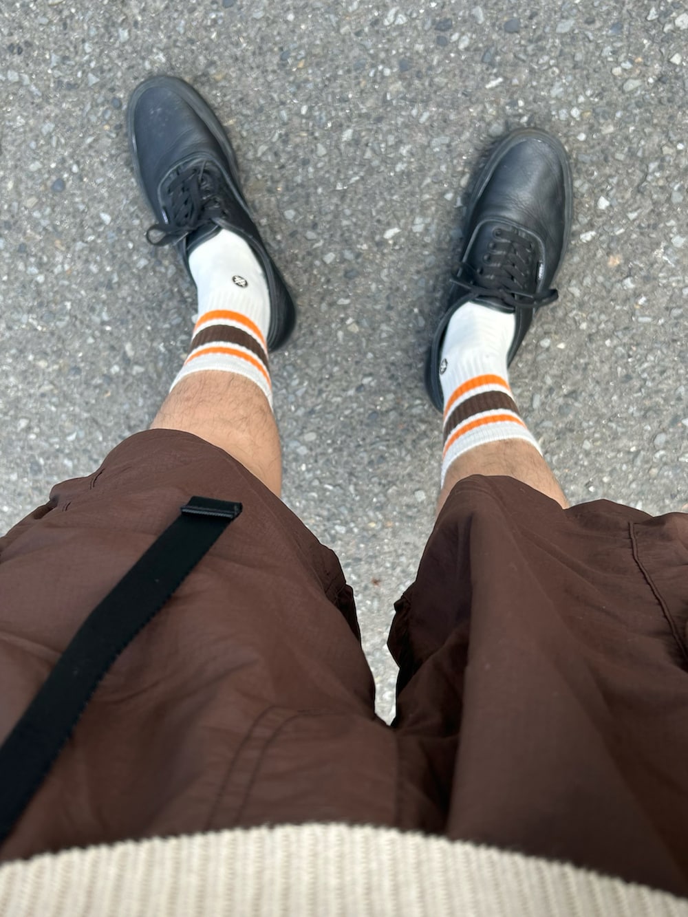 ベージュ系のニット/セーター、ブラウン系のパンツ、ブラック系のスニーカーを着用したメンズの夏コーディネートの4枚目の写真