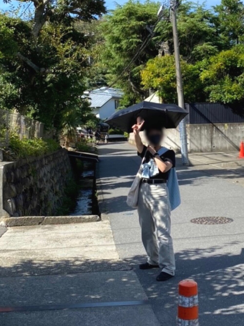 グレー系のデニムパンツ、オレンジ系のトートバッグ、グリーン系のシャツ/ブラウスを着用したレディースの秋コーディネートの2枚目の写真