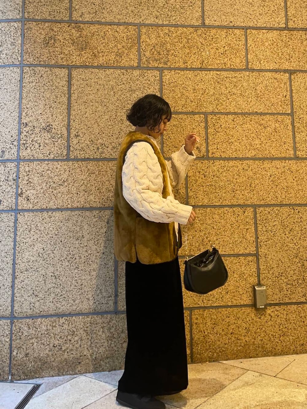 ブラウン系のその他アウター、ブラック系のスニーカー、ブラック系のスカートを着用したレディースの冬コーディネートの3枚目の写真