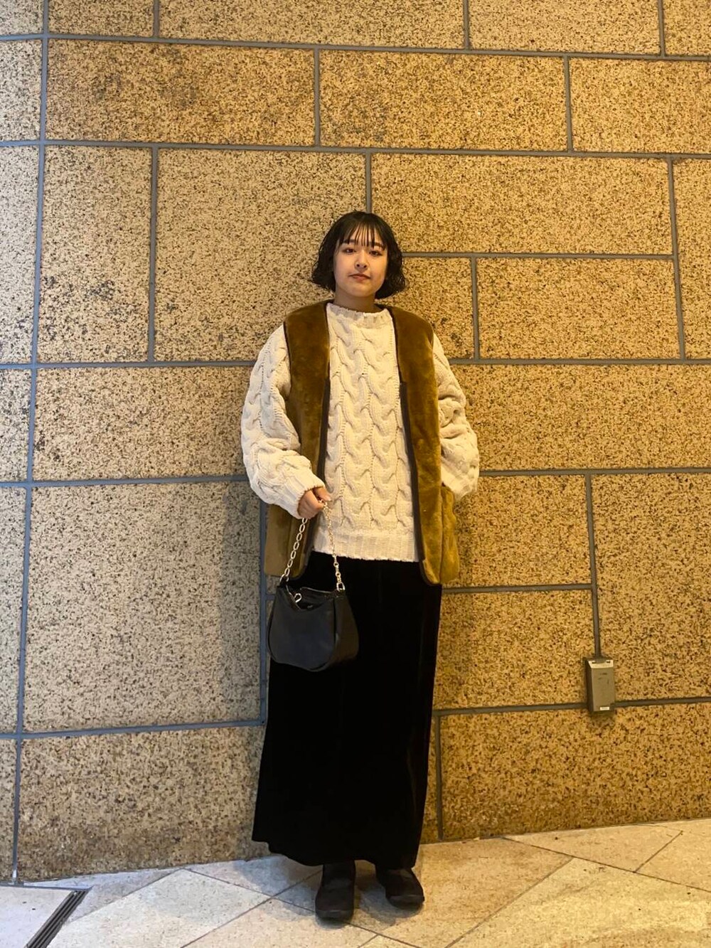 ブラウン系のその他アウター、ブラック系のスニーカー、ブラック系のスカートを着用したレディースの冬コーディネートの2枚目の写真