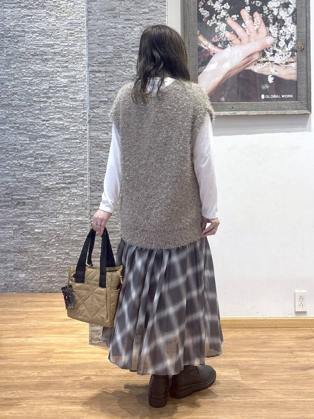 ブラウン系のトートバッグ、ブラウン系のスカート、ブラウン系のベストを着用したレディースの秋コーディネートの4枚目の写真