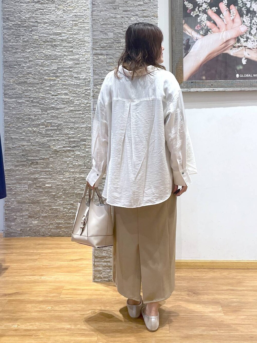 ホワイト系のバレエシューズ、ベージュ系のワンピース、ブラウン系のTシャツ/カットソーを着用したレディースの夏コーディネートの3枚目の写真