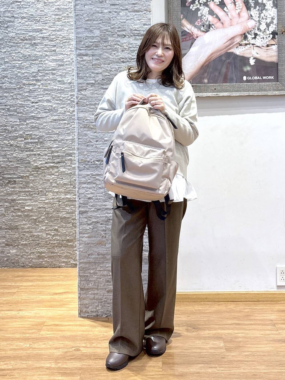 ブラック系のバックパック/リュック、ベージュ系のダウンジャケット/コート、ブラウン系のスウェットを着用したレディースの秋コーディネートの6枚目の写真