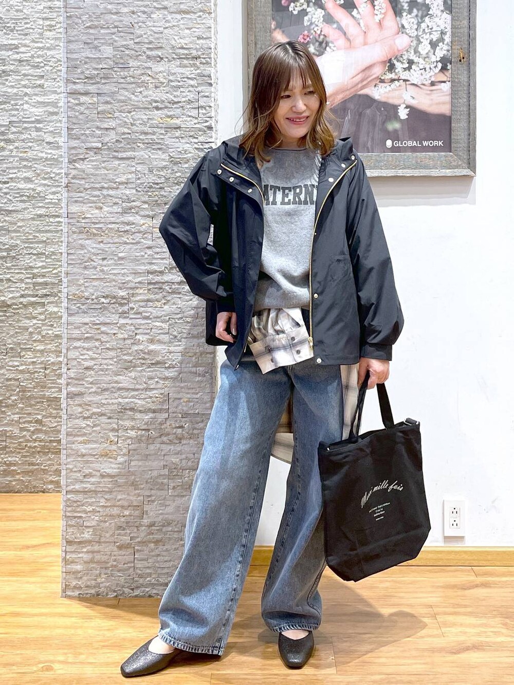 ブルー系のデニムパンツ、ブラック系のパンプス、ブルー系のマウンテンパーカーを着用したレディースの春コーディネートの2枚目の写真