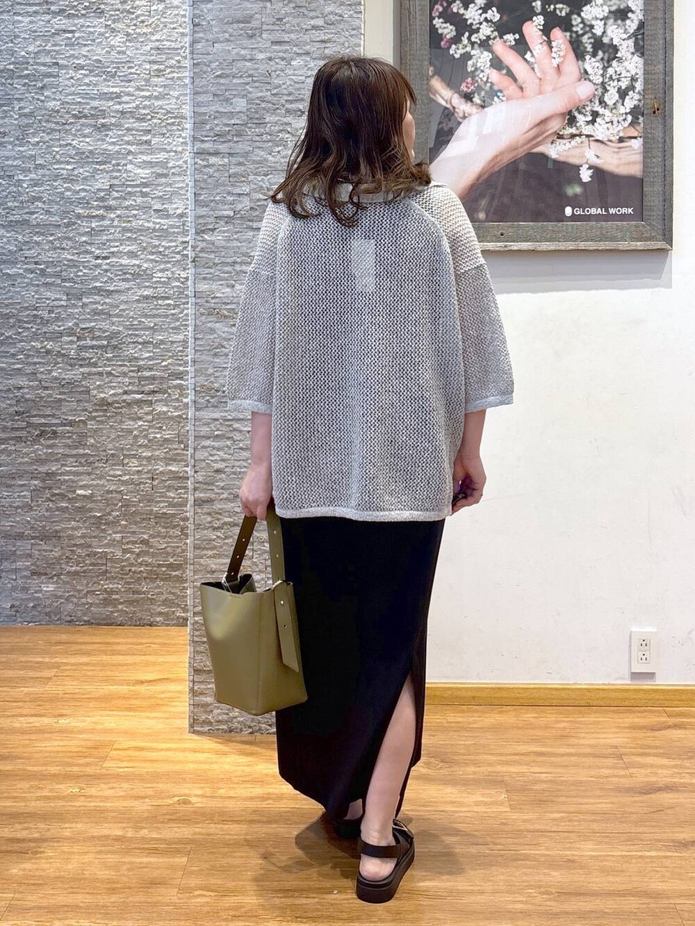 グリーン系のショルダーバッグ、ブラウン系のタンクトップ、ブラック系のサンダルを着用したレディースの夏コーディネートの3枚目の写真