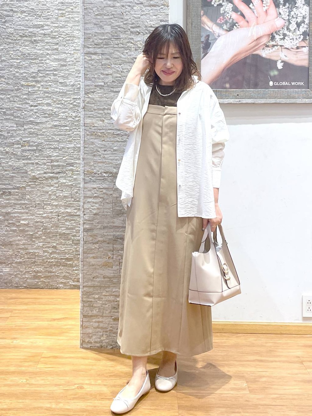 ホワイト系のバレエシューズ、ベージュ系のワンピース、ブラウン系のTシャツ/カットソーを着用したレディースの夏コーディネートの2枚目の写真