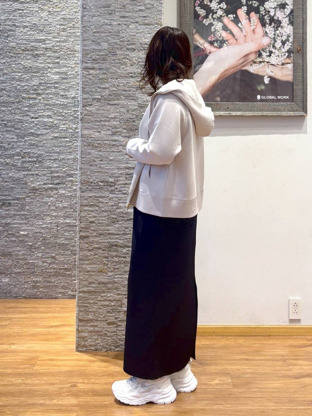 ホワイト系のショルダーバッグ、ブラック系のスカート、ホワイト系のスニーカーを着用したレディースの秋コーディネートの2枚目の写真