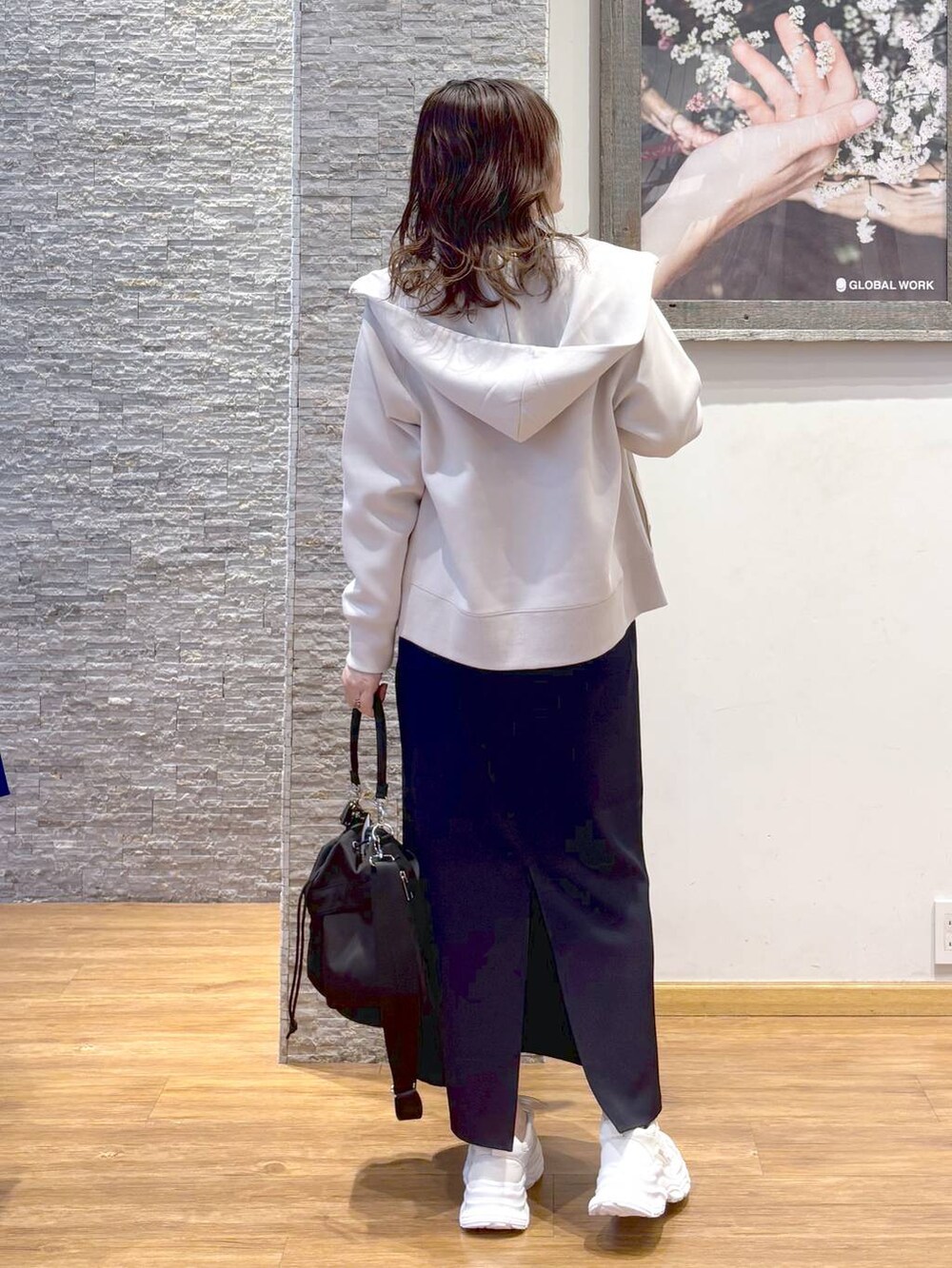 ホワイト系のショルダーバッグ、ブラック系のスカート、ホワイト系のスニーカーを着用したレディースの秋コーディネートの3枚目の写真