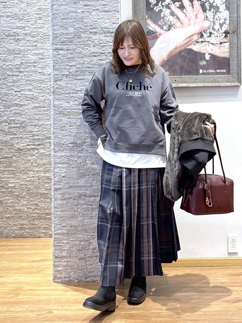 レッド系のボストンバッグ、ブラック系のブルゾン、ホワイト系のTシャツ/カットソーを着用したレディースの秋コーディネートの6枚目の写真