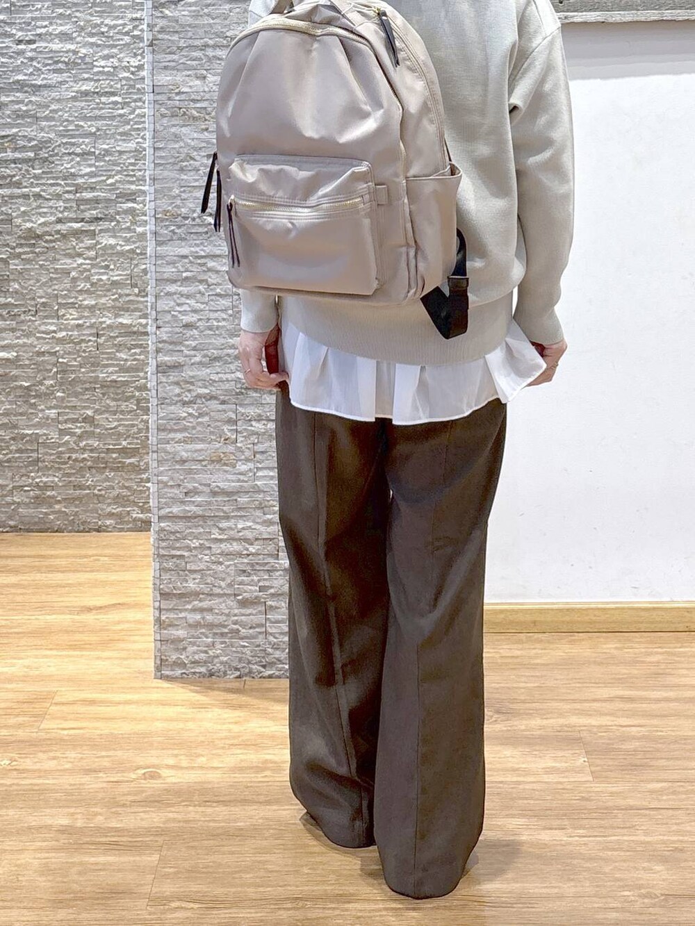 ブラック系のバックパック/リュック、ベージュ系のダウンジャケット/コート、ブラウン系のスウェットを着用したレディースの秋コーディネートの5枚目の写真