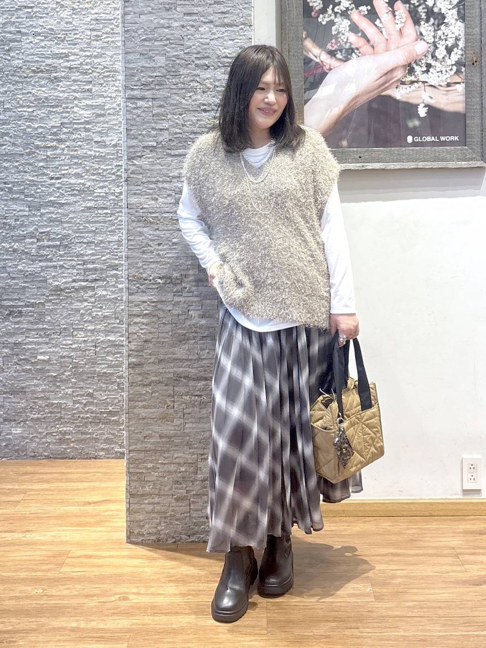 ブラウン系のトートバッグ、ブラウン系のスカート、ブラウン系のベストを着用したレディースの秋コーディネートの5枚目の写真